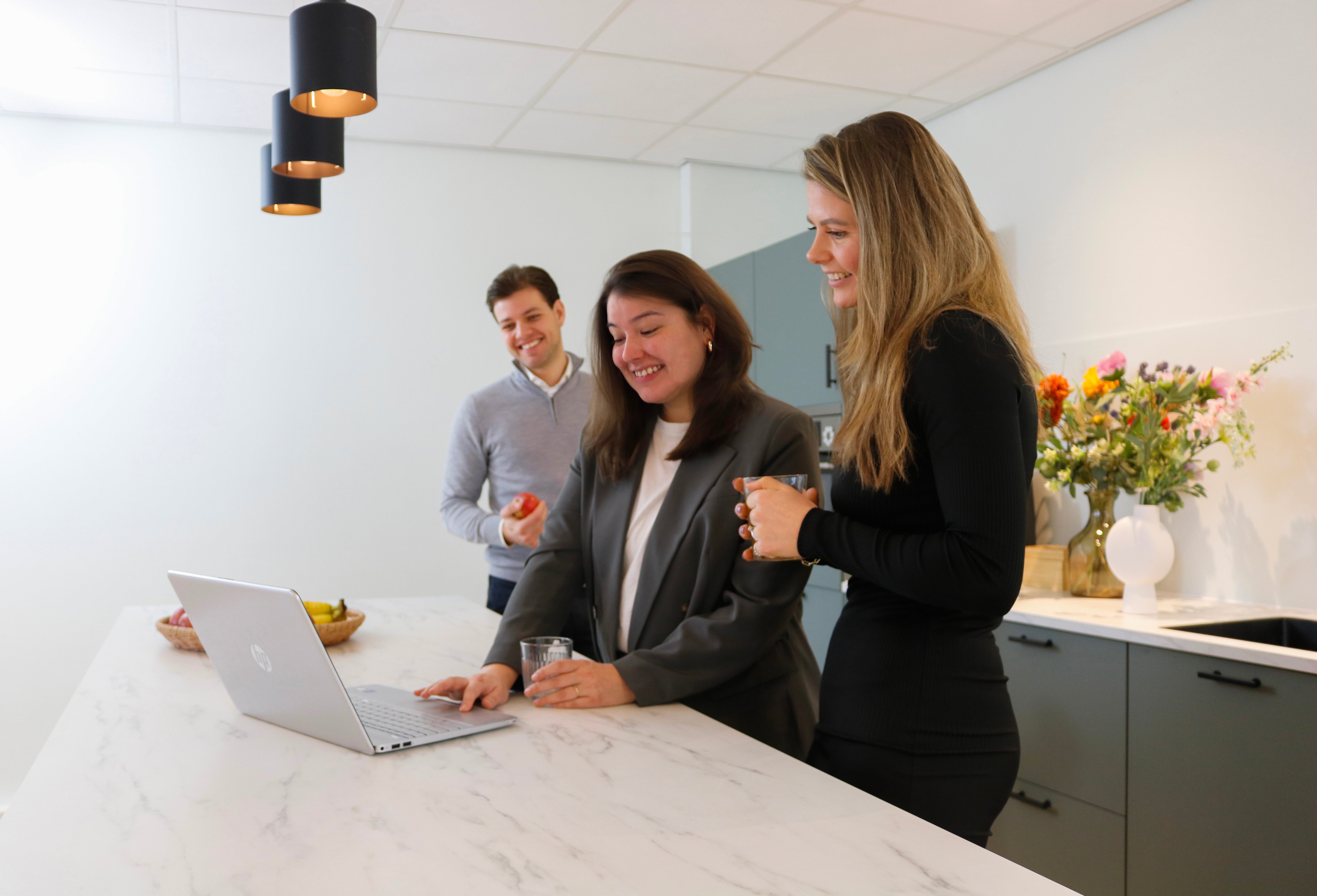 Drie mensen kijken naar laptop